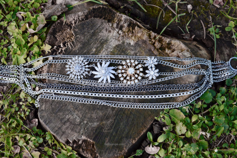 Necklace with multiple chains and rhinestone flowers.