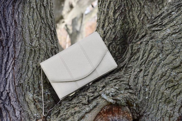Light gold envelope bag on a tree branch.