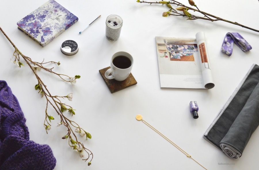 Spring Cleaning Flatlay: tea, chia pudding, magazine, flowers, nail polish, gold pendant, and journal. 