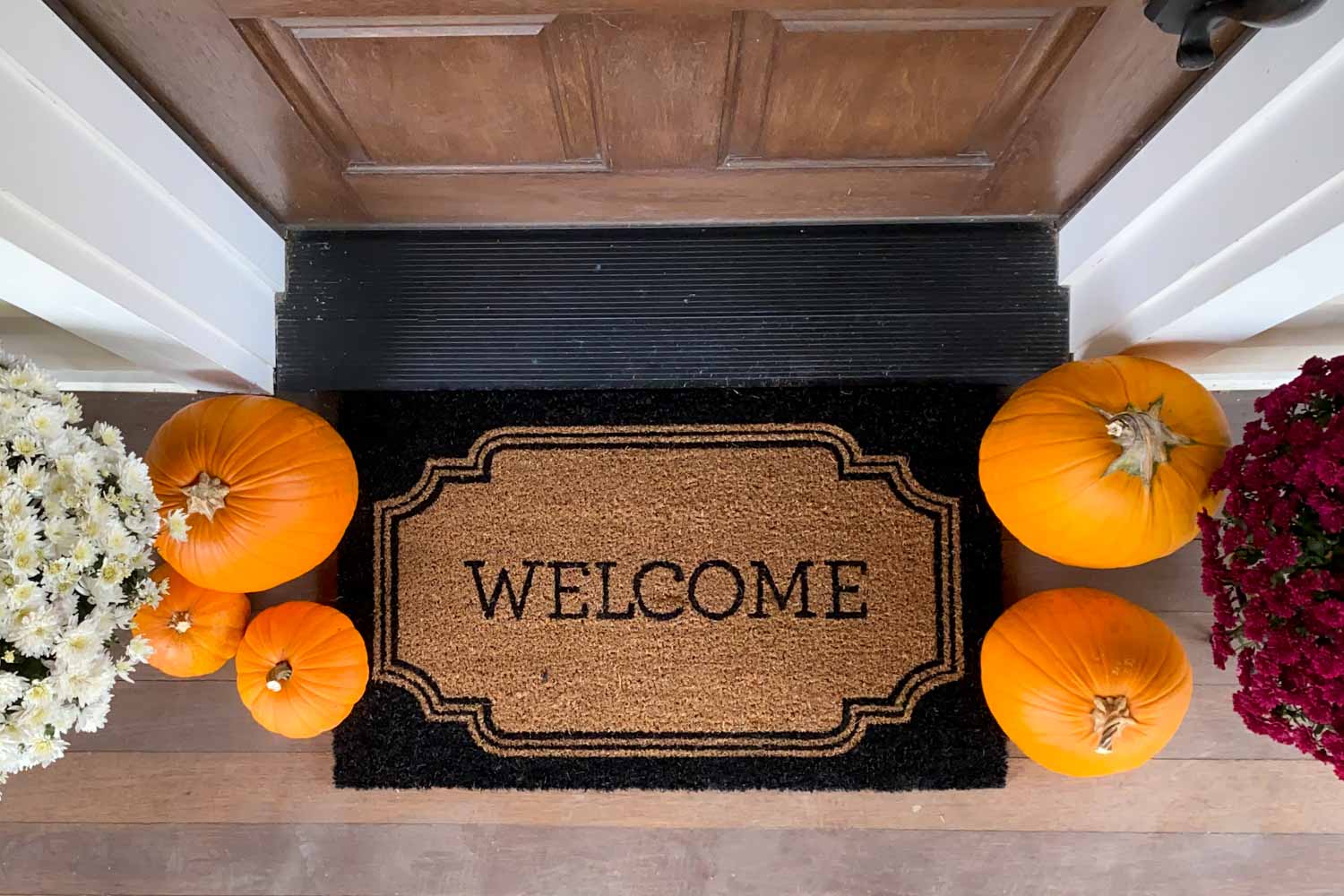 Welcome mat and pumpkins