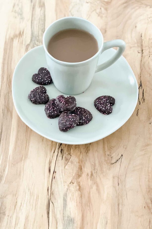Tea and heart shaped cookies with sprinkles.