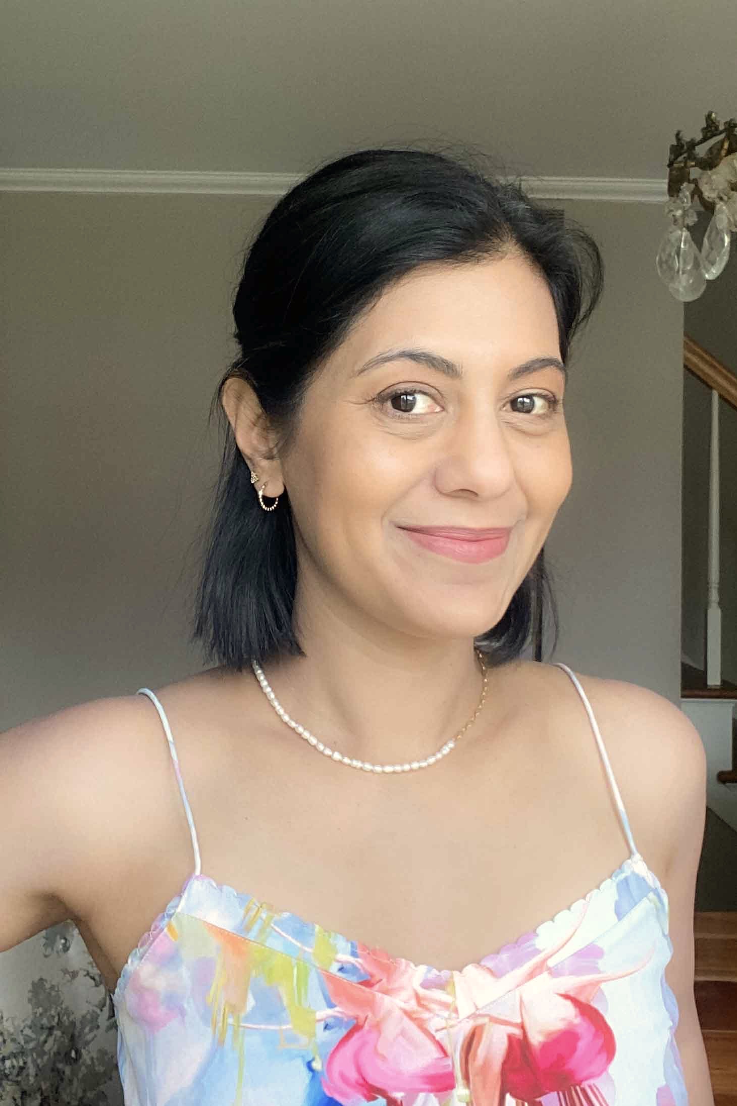 Portrait of Fashionipa wearing pearl and chain necklace and printed camisole top