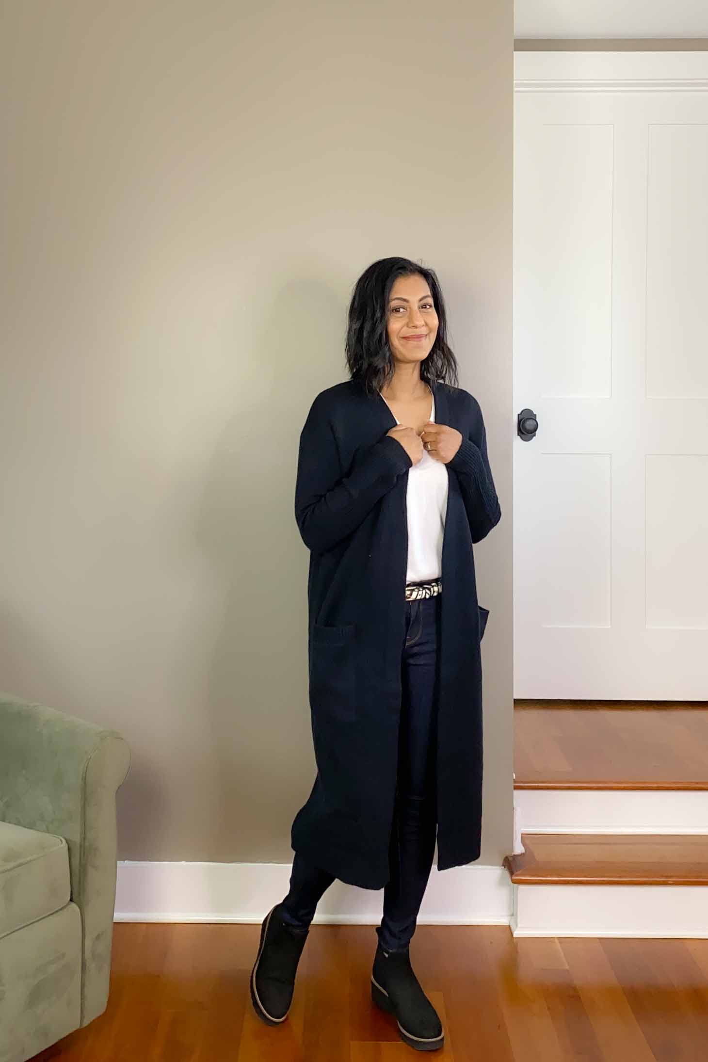 Fashionipa wearing mid-rise skinny jeans, a white v-neck t-shirt, long cardigan and booties