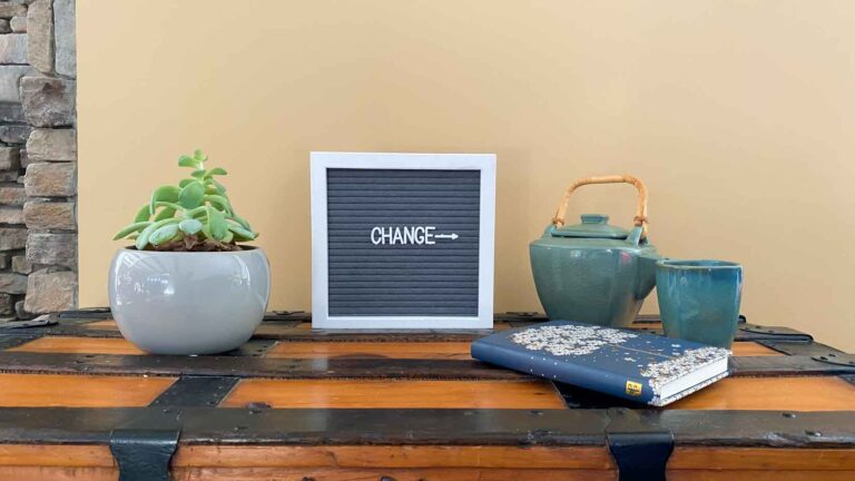 Succulent, frame with the word change, tea pot and cup, and journal.