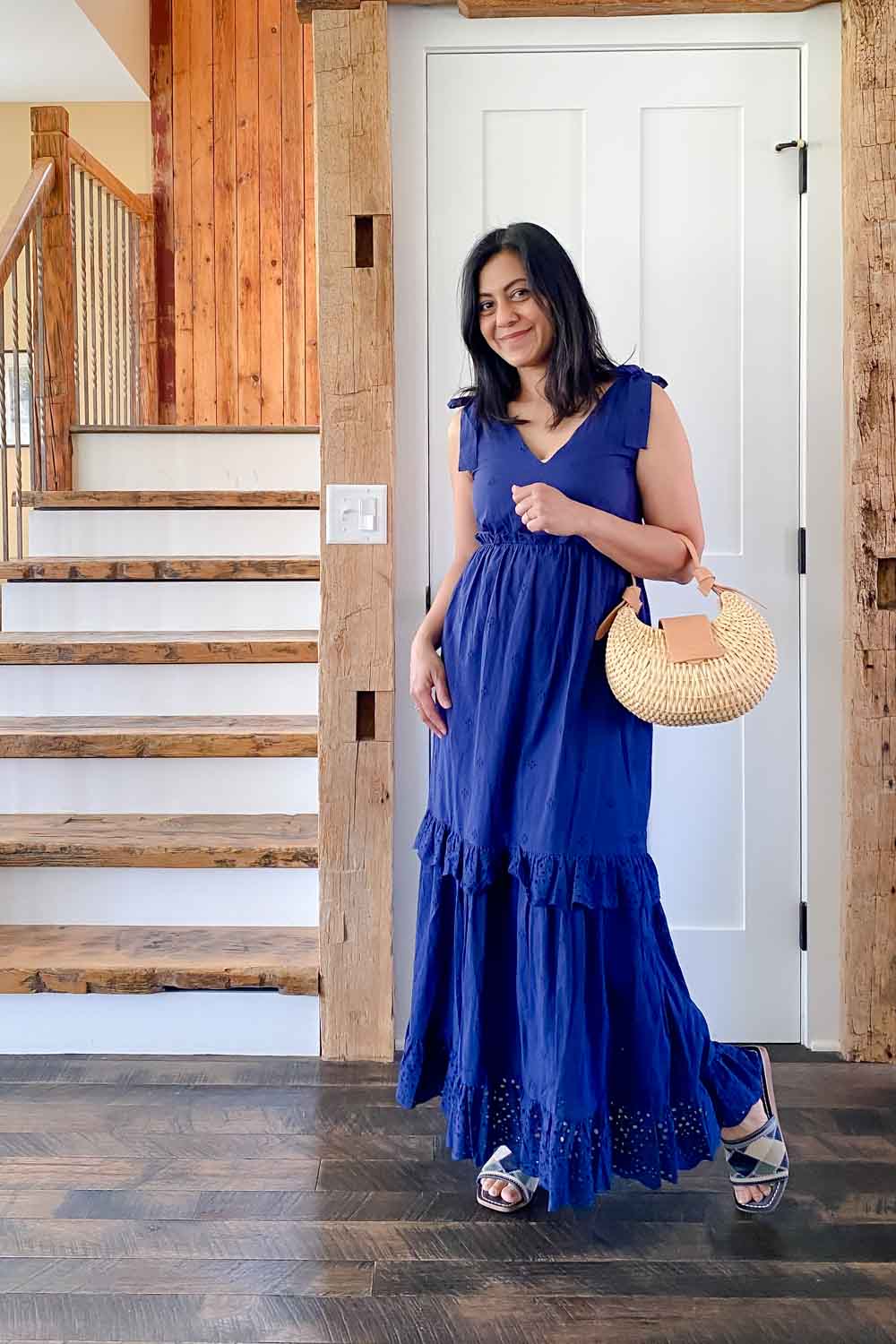 Fashionipa wearing a blue eyelet dress carryin g a basket bag