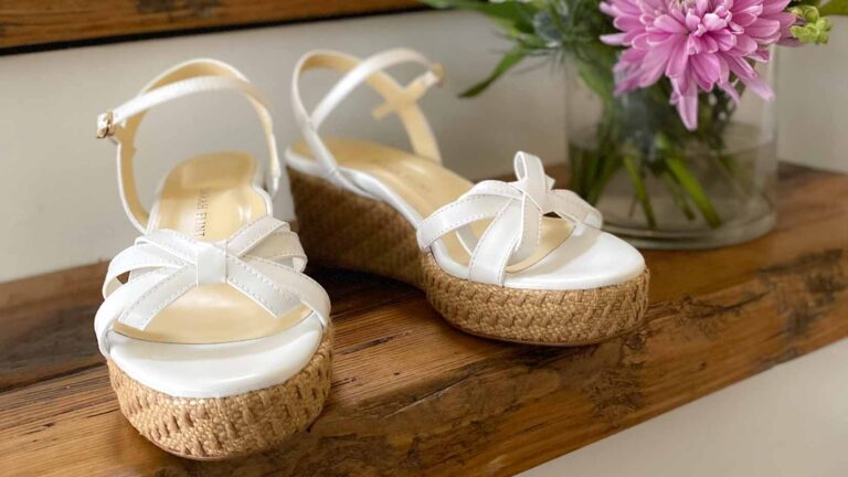 Sarah Flint Mirjana Wedge 50 Sandals in white on a step next to flowers