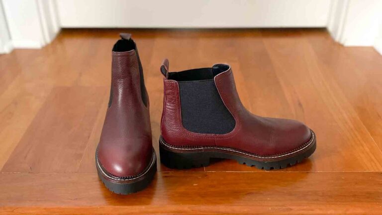 Burgundy lug sole Chelsea boots on a wooden floor