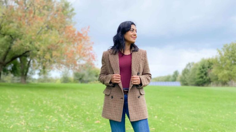 Fashionipa (Nipa) wearing a brown houndstooth check blazer and a wine colored t-shirt in front of a tree with green and orange leaves.