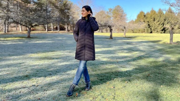Fashionipa (Nipa) wearing a black puffer coat with jeans and black boots. She is standing outside on frost covered grass.