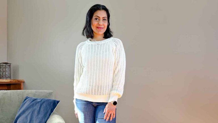 Fashionipa (Nipa) wearing a cream open knit sweater with bootcut jeans and boots.