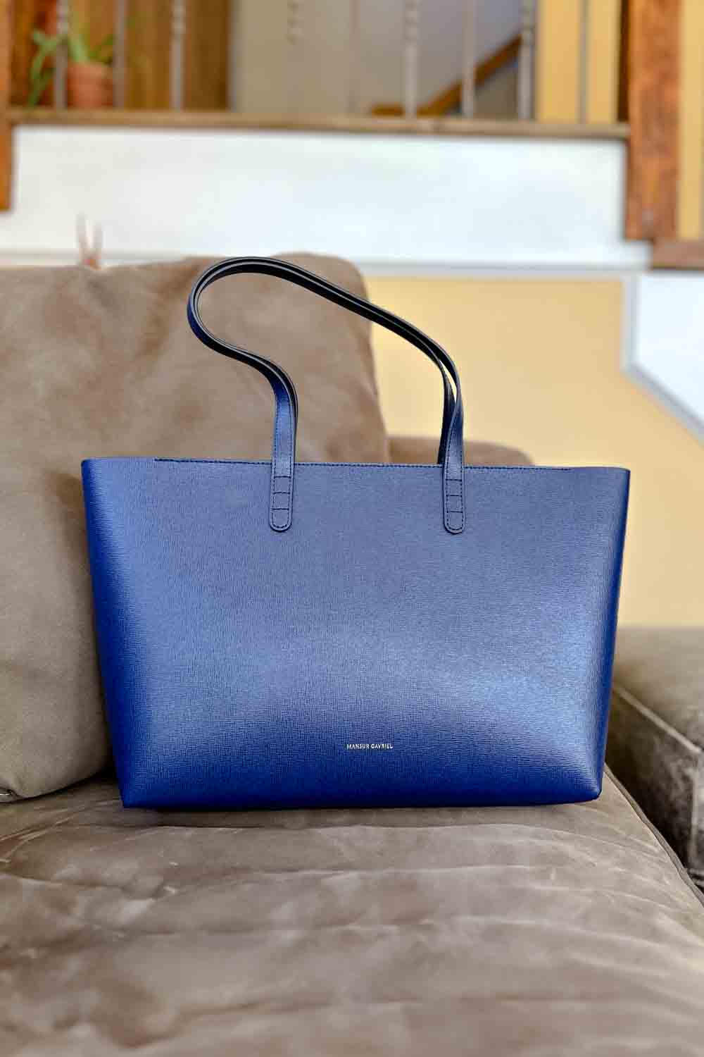 A blue tote bag on a tan couch.