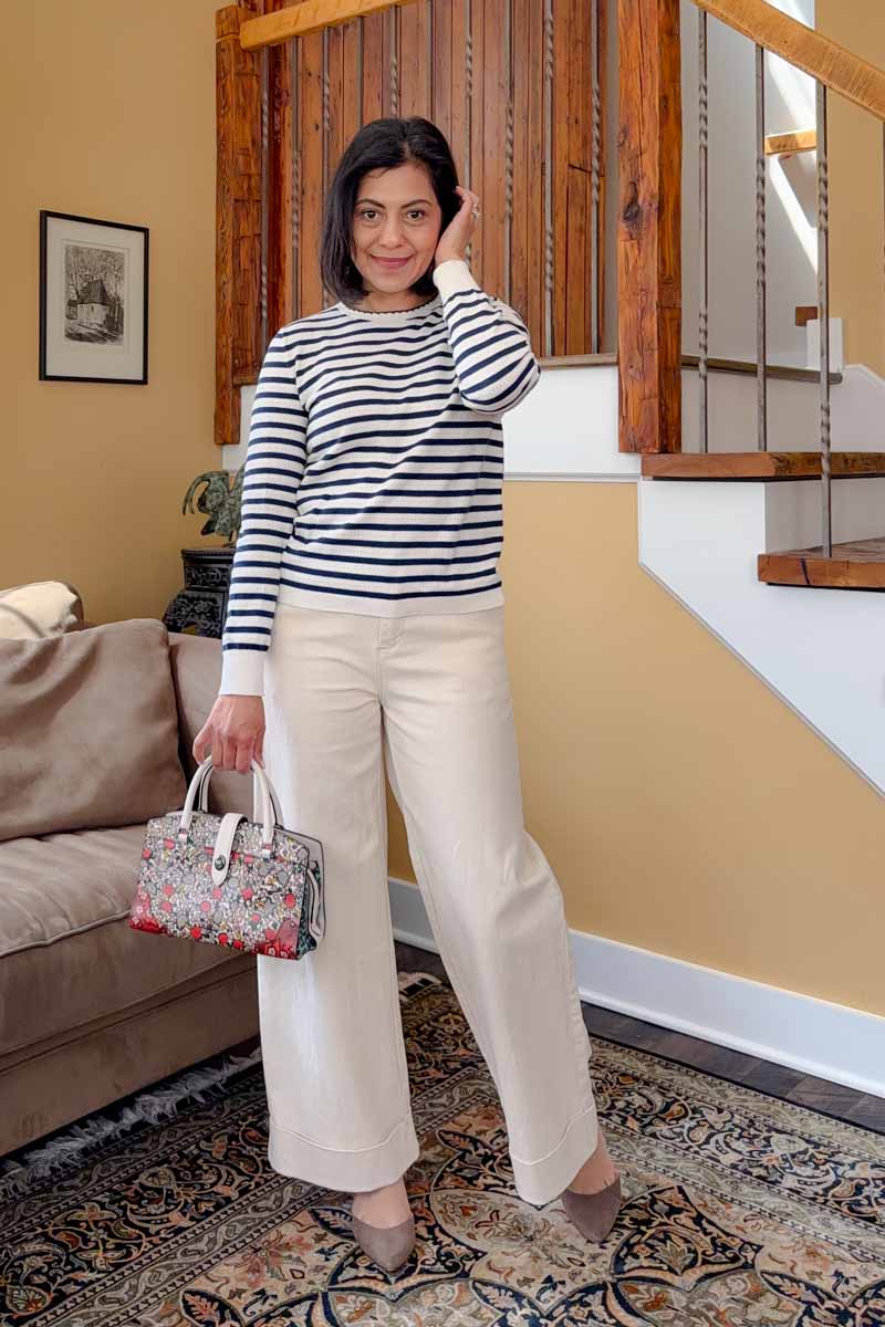 Fashionipa (Nipa) wearing a black and white striped top with ecru jeans, black sneakers and a floral handbag.