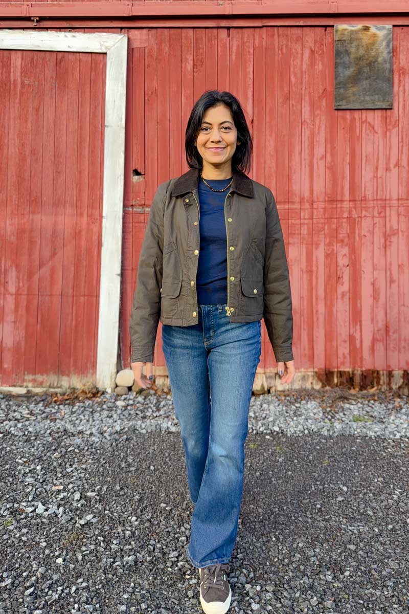Fashionbipa (Nipa) wearing a brown barn jacket, blue sweater, flared jeans and brown sneakers.