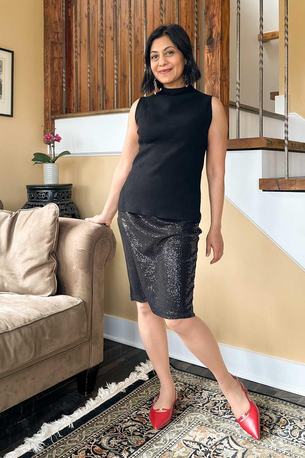 Fashionipa (Nipa) wearing a black sequin skirt with a mock-neck sleeveless sweater and red flats.