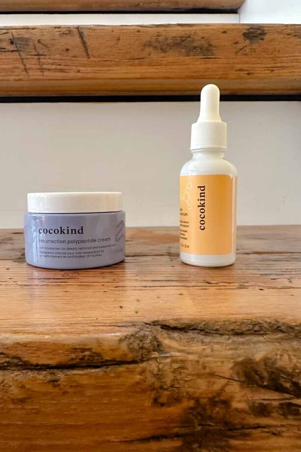 Cocokind moisturizer and serum on a wooden step.