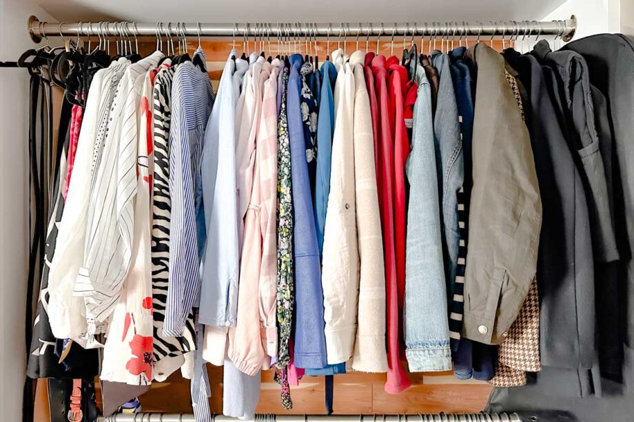 Jackets and blouses hanging in a closet. 