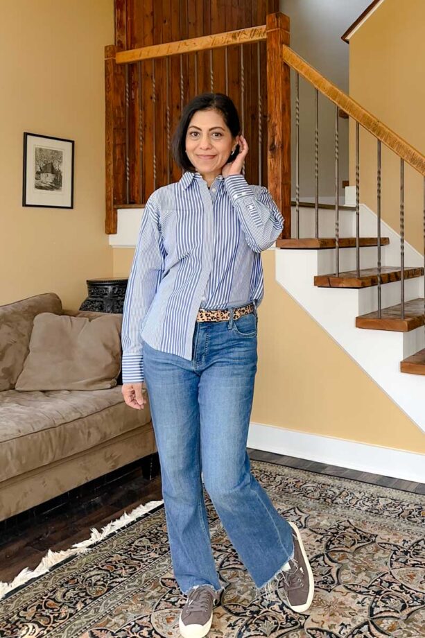 Fashionipa (Nipa) wearing a blue and white striped shirt (with varied stripes) French tucked into jeans, with a leopard belt and brown sneakers.