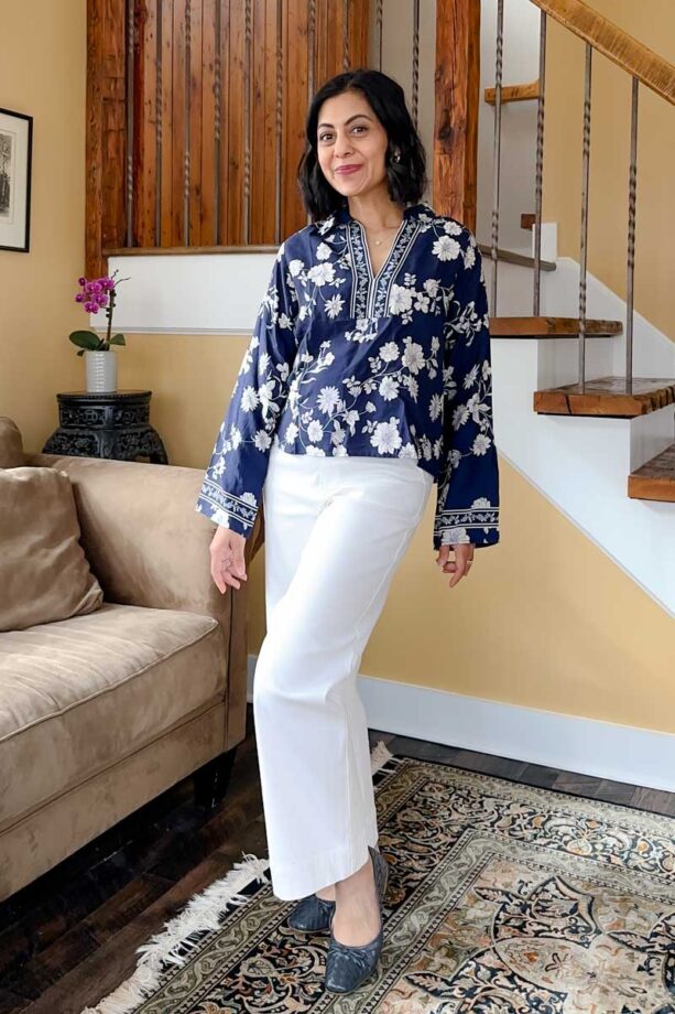 Fashionipa (Nipa) wearing a blue and white print floral popover top with white jeans and blue ballet flats.