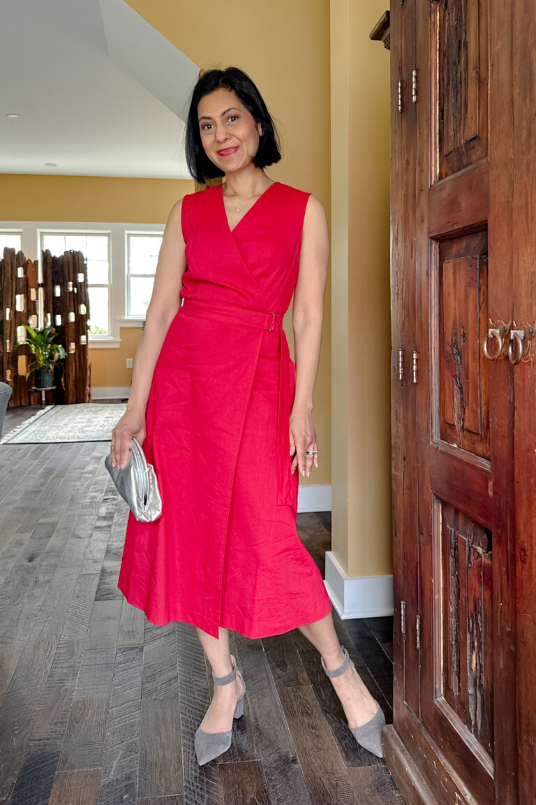 Fashionipa (Nipa) wearing a red wrap dress with gray shoes and a silver clutch.