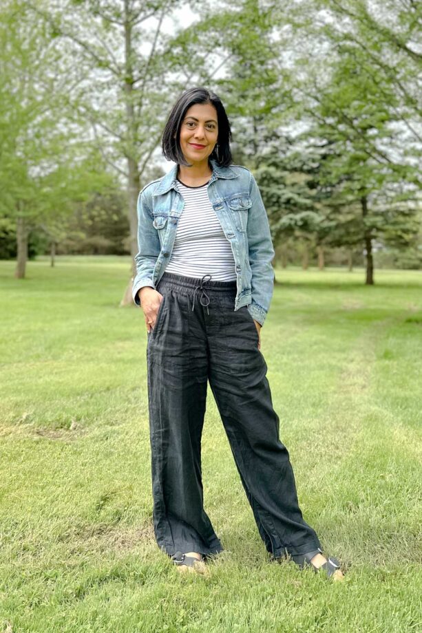 Fashionipa (Nipa) wearing a denim jacket, black wide leg linen pants, a black and white striped tank top and black sandals.
