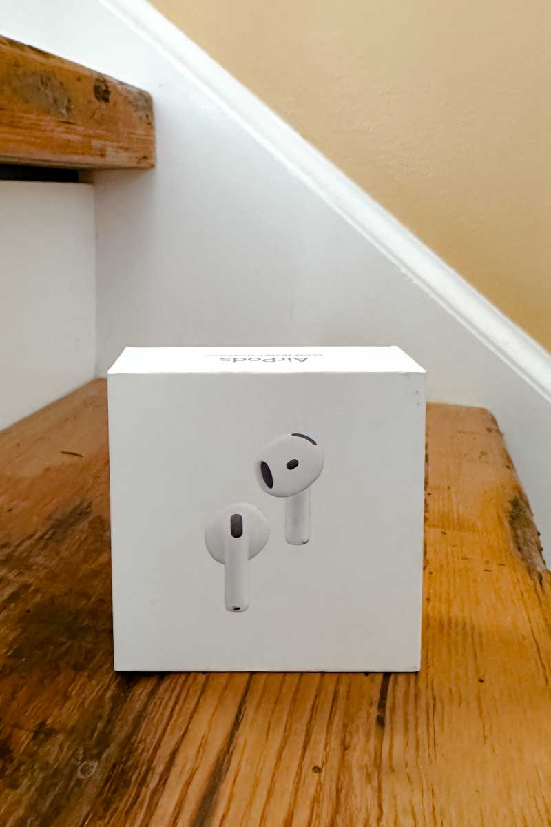AirPods in the box on a wooden step
