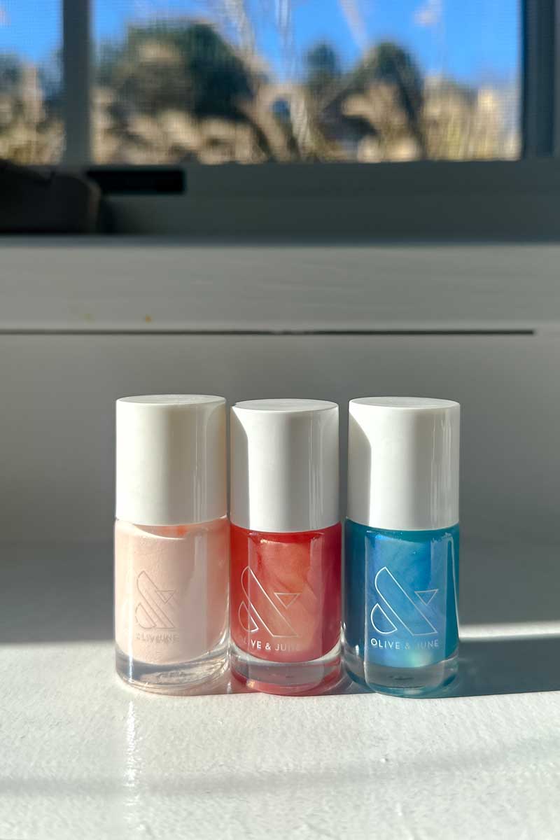 3 bottles of Olive & June nailpolish in pink, peach and sky blue.