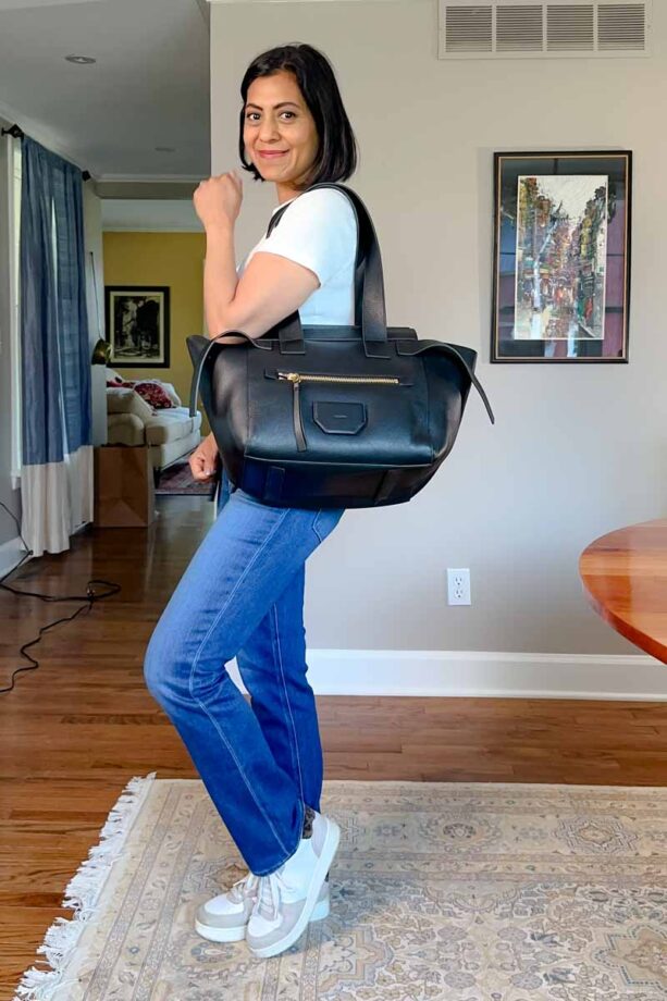 Fashionipa (Nipa) wearing a white t-shirt, jeans, carrying a large black leather tote.