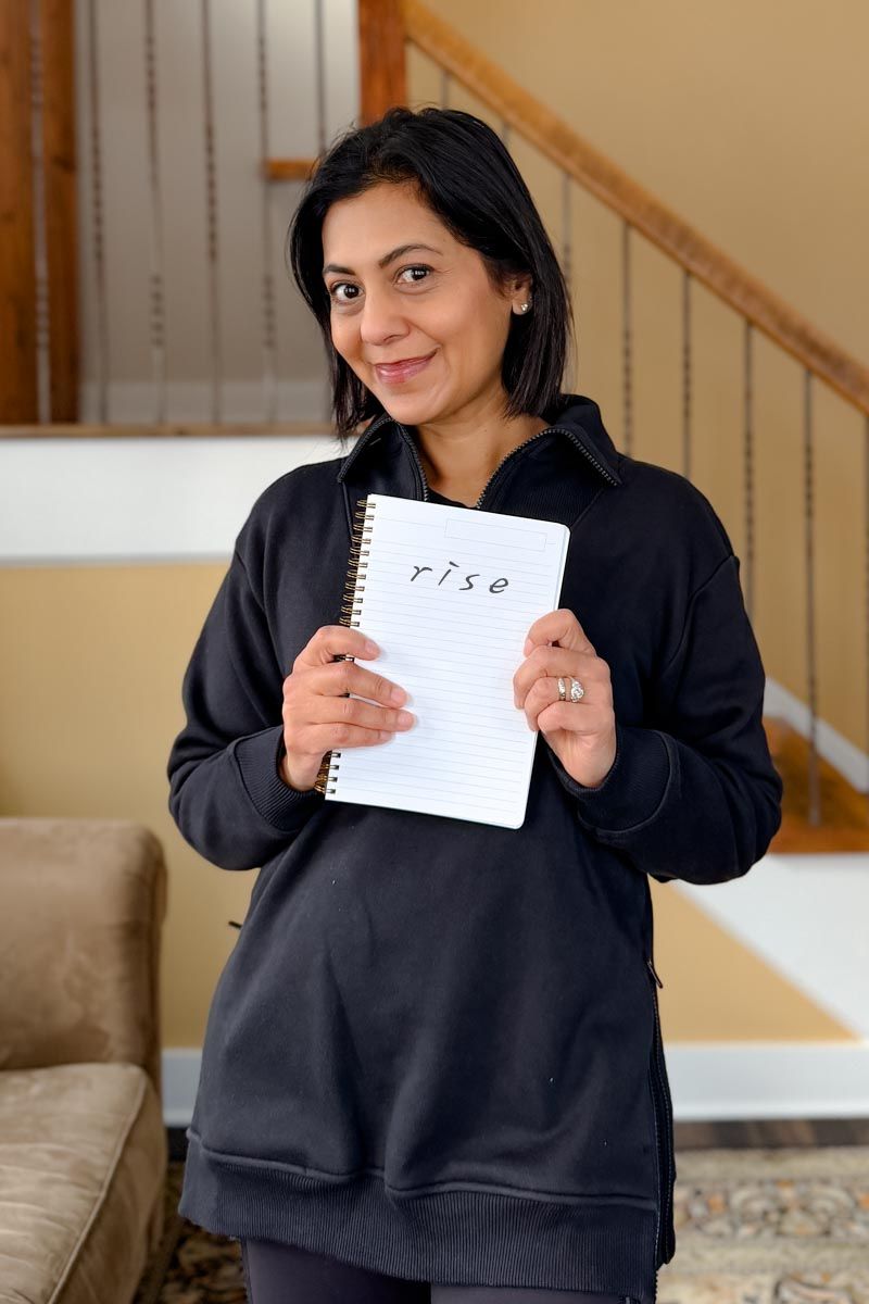 Fashionipa (Nipa) holding a notebook with the word rise on it.
