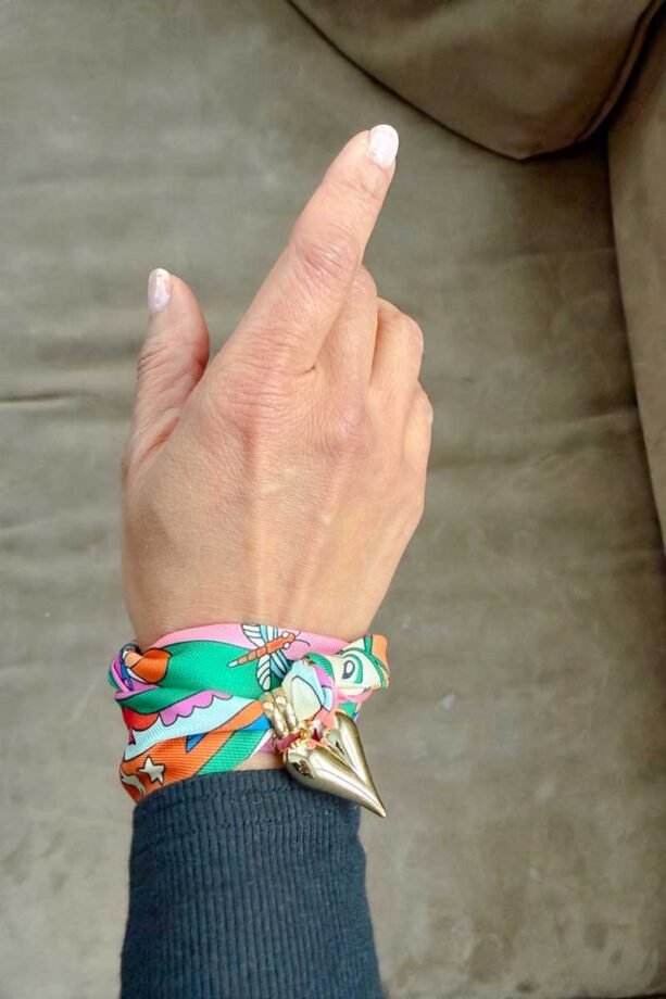 Fashionipa (Nipa) wearing a scarf with a heart charm on her wrist.
