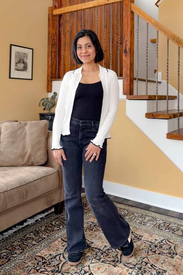 Fashionipa (Nipa) wearing a white pointelle cardigan with a black camisole, jeans and sneakers.