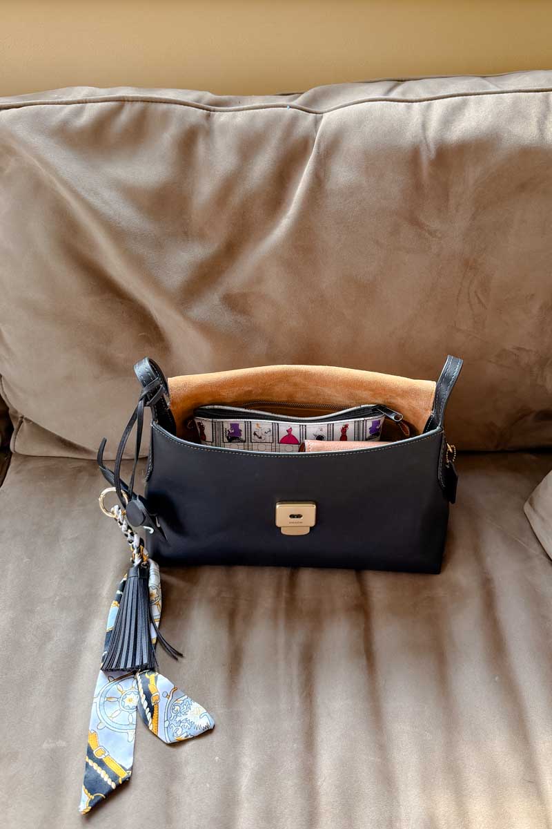 Coach Chelsea 30 handbag open with a makeup bag and wallet showing inside.