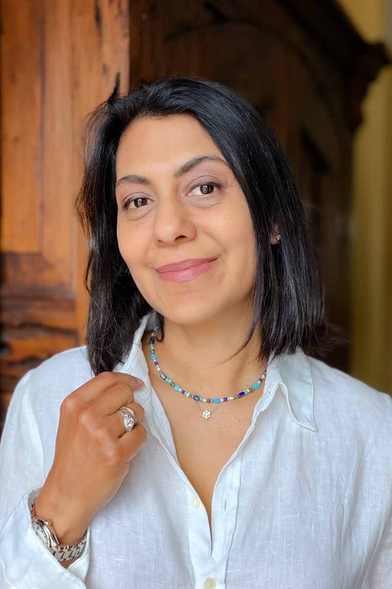 Fashionipa (Nipa) wearing a white shirt and a blue beaded necklace.