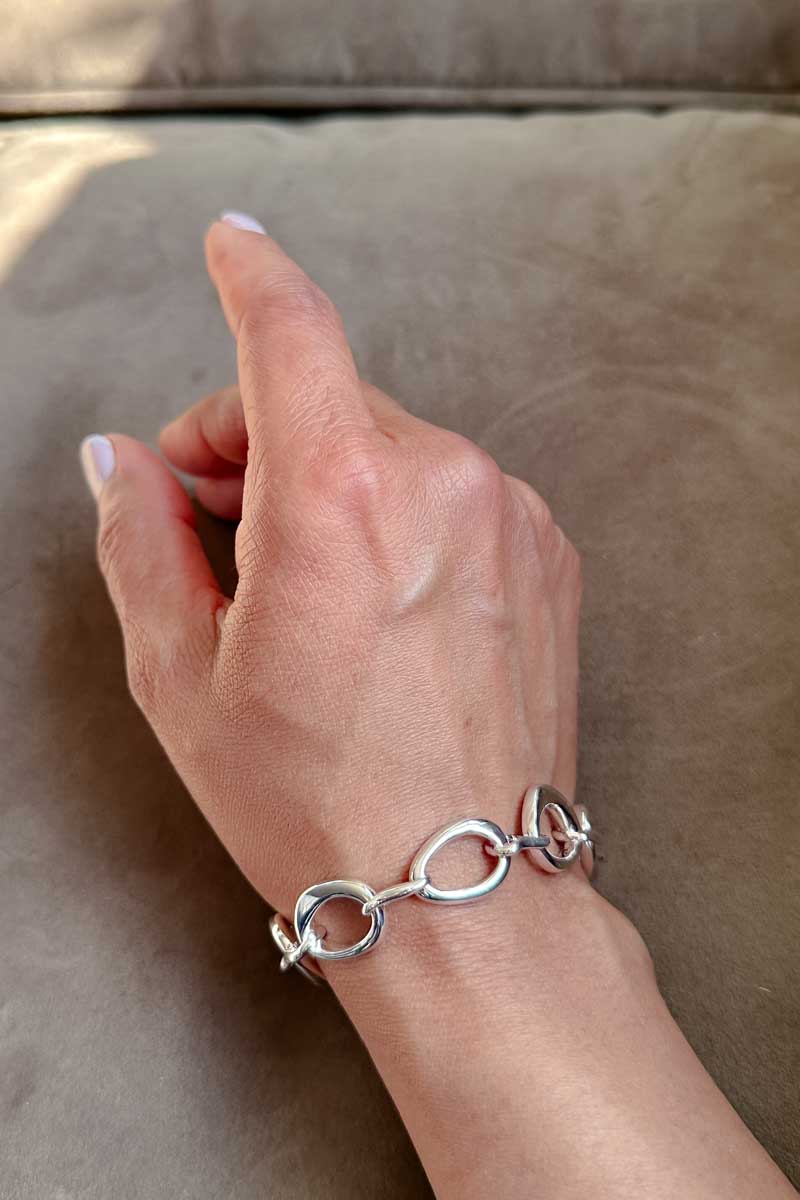 A woman's hand wearing a chain link bracelet.