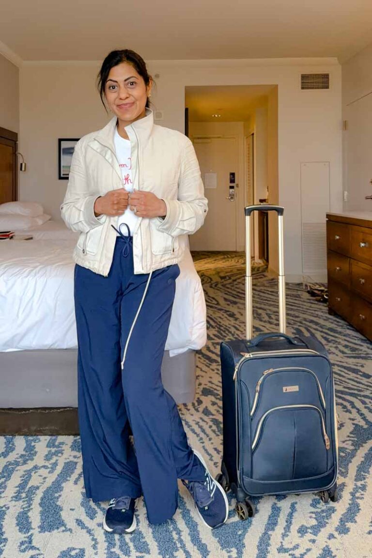 Fashionipa (Nipa) wearing a tan jacket, white tee, blue athletci pants and blue sneakers.