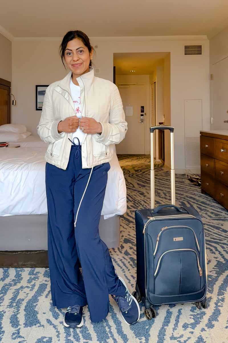 Fashionipa (Nipa) wearing a tan jacket, white tee, blue athletci pants and blue sneakers.