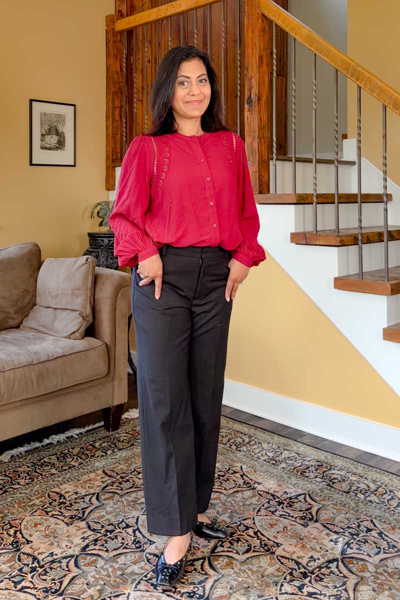 Fashionipa (Nipa) wearing a red blouse with cutout details, with black tailored poants and ballet flats.