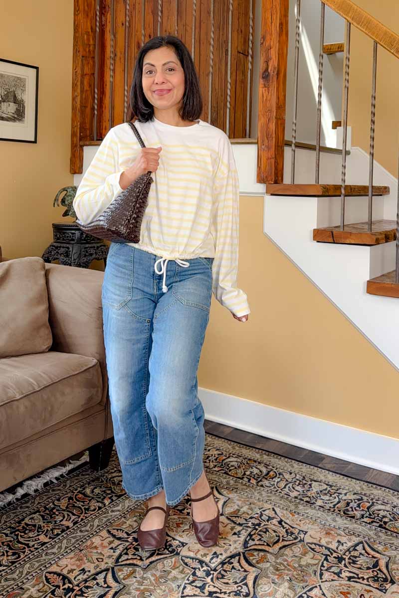 Fashionipa (Nipa) wearing a yellow striped top, utility style jeans, ballet flats and a woven handbag.